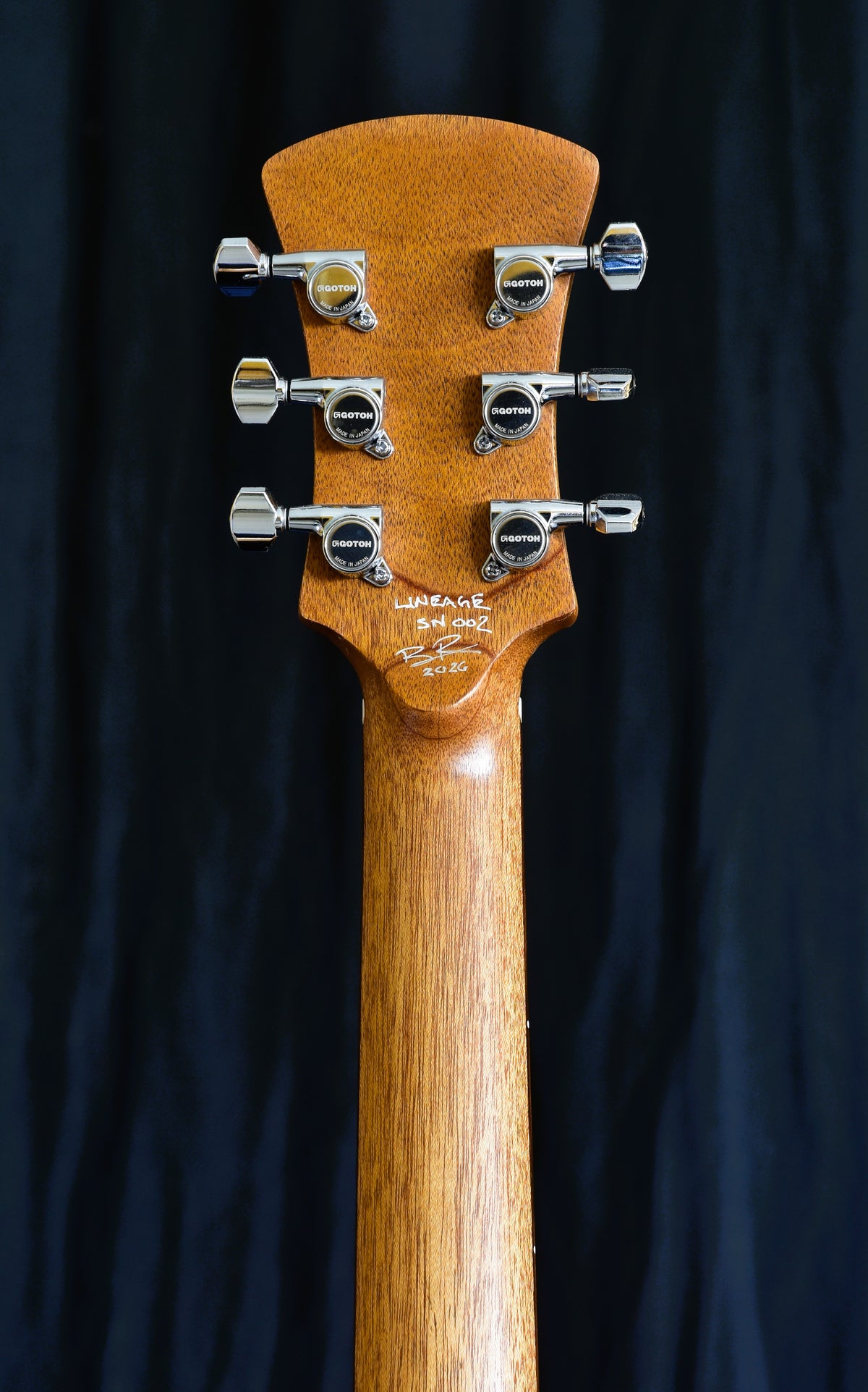 Rear view of the Lineage 6 headstock and neck showing custom BR logo locking tuners